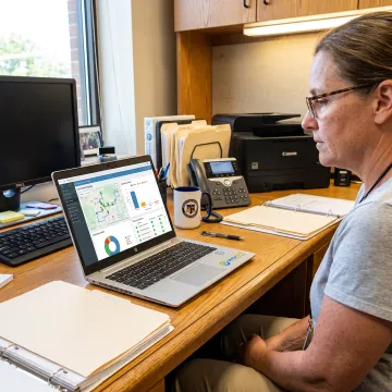 Transportation coordinator reviewing digital compliance reports