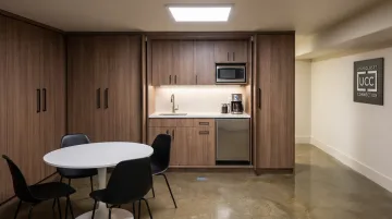 Custom commercial break room cabinetry installation with concealed kitchenette storage