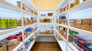 Organized walk-in pantry with labeled zones baskets and LED under-shelf lighting