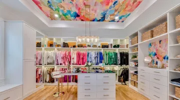 Walk-in closet interior with bold wallpaper accent panel and open shelving display