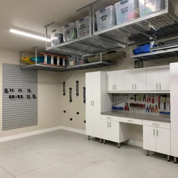 Organized garage with custom cabinets and overhead storage