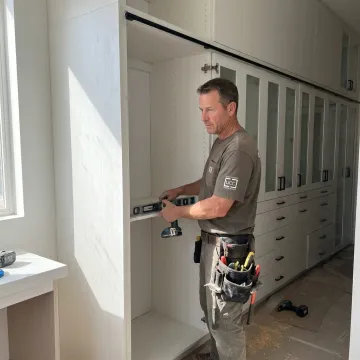Installer fitting custom living room cabinets