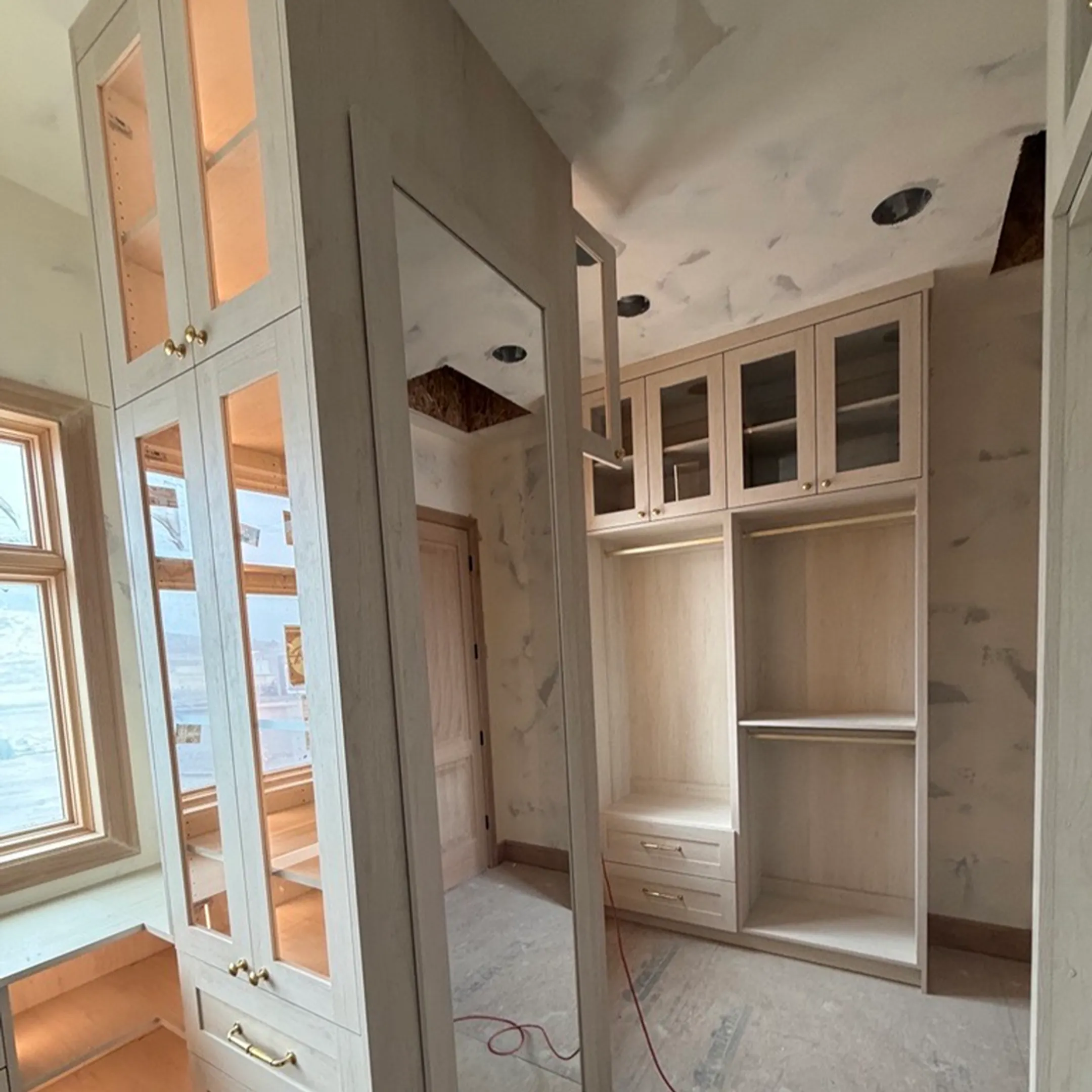 Designer measuring a walk-in closet for custom shelving