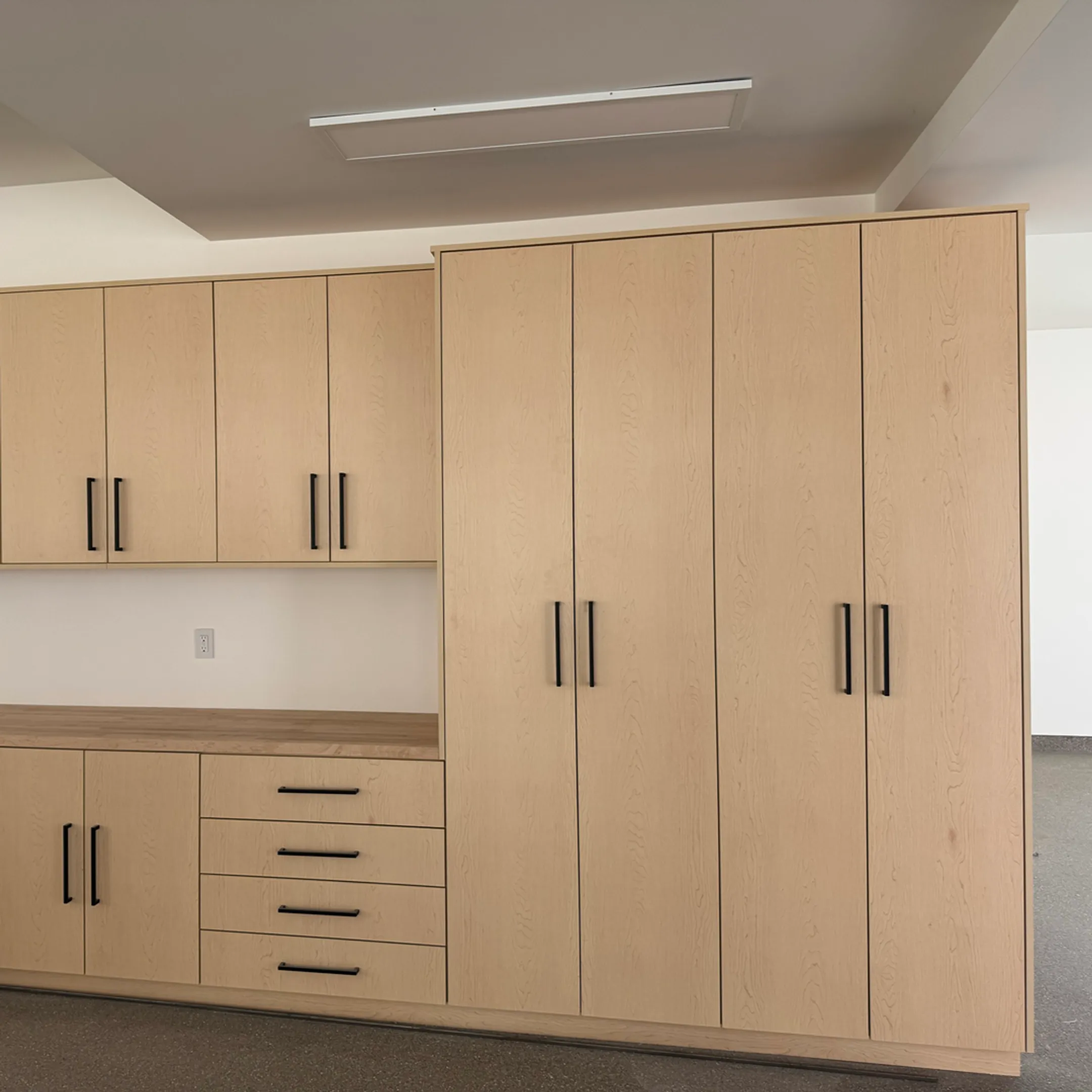 Installer measuring garage wall cabinets