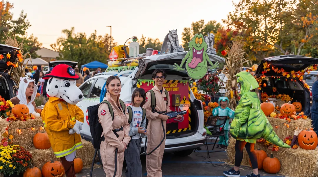 Community costume parade with families celebrating Halloween fundraiser event