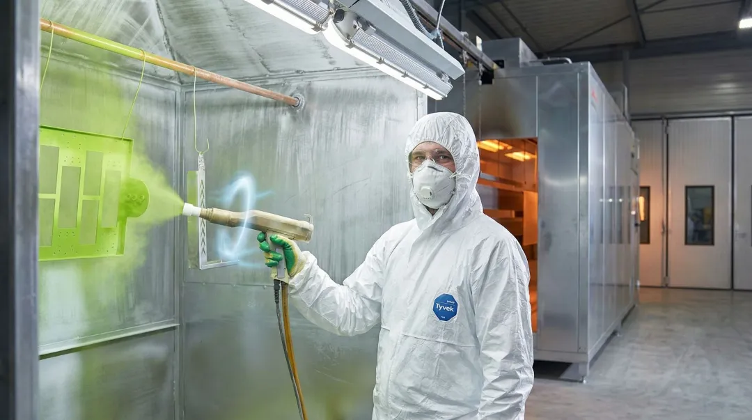 Industrial powder coating process showing electrostatic spray gun applying polymer coating to aluminum part