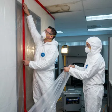 Commercial remediation crew setting containment barriers