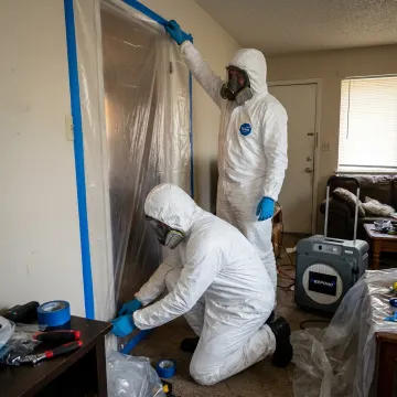 Biohazard cleanup crew preparing containment