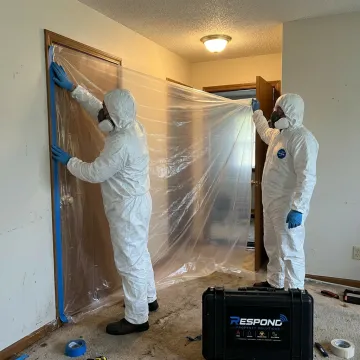 Biohazard cleanup technicians preparing containment