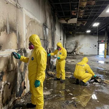 Commercial restoration crew reviewing large loss damage