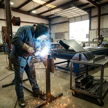 Metal fabricator welding custom steel assembly