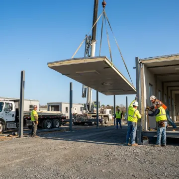 Crew installing a modular office at an industrial site