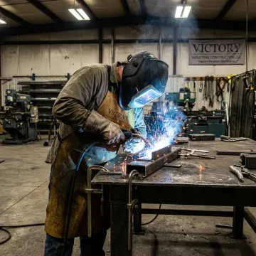 Welder fabricating a steel component