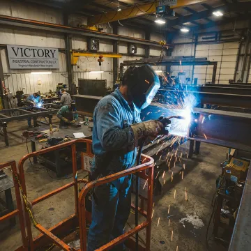 Fabricators welding heavy steel components