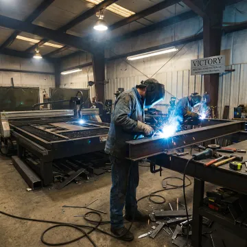 Industrial metal fabrication team welding a custom steel component