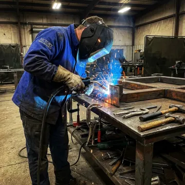MIG welder fabricating a steel component