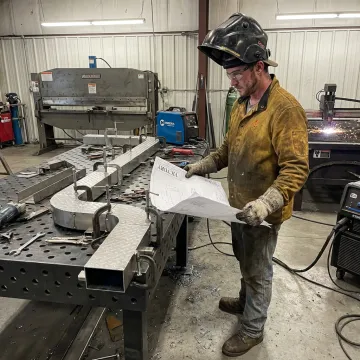 Welder following fabrication plans