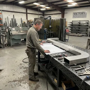 Fabricator reviewing stainless steel drawings before welding