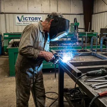 Metal fabricator welding a steel frame