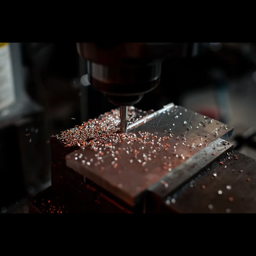 Fabricator reviewing CAD drawings near CNC equipment