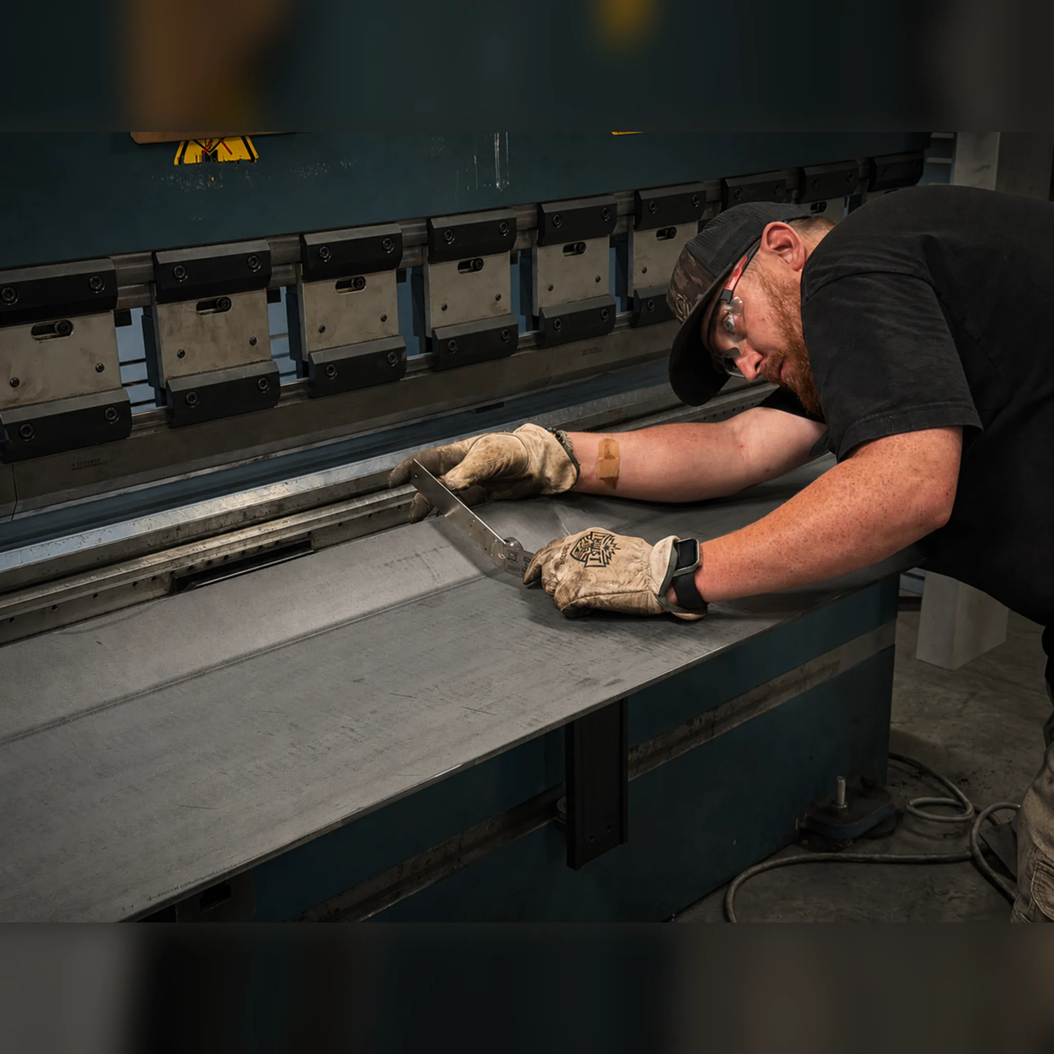 Fabrication team reviewing CAD plans near welded parts