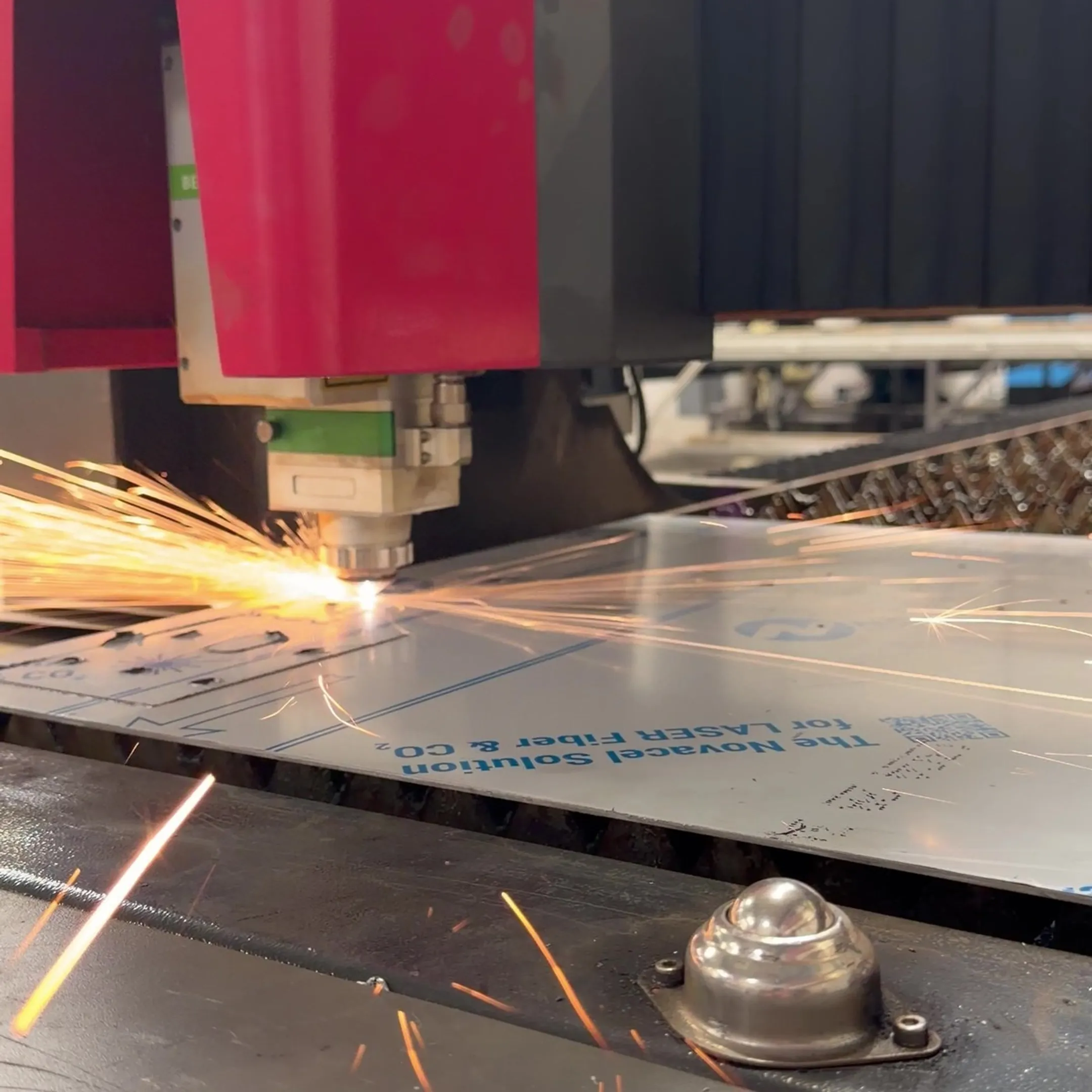 Fabricator reviewing drawings beside metal parts