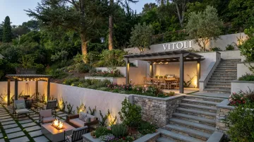 Engineered hillside terrace with stone patio fire pit and pergola dining area