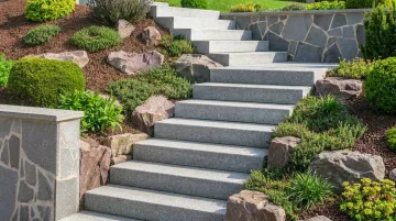 Completed natural stone hillside steps with proper drainage pitch and edge boulders