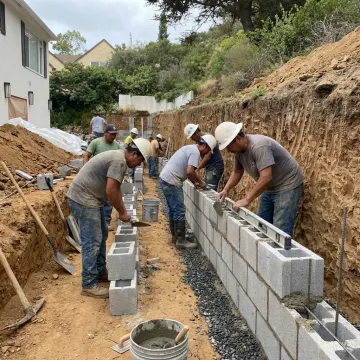 Crew constructing a hillside retaining wall