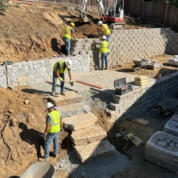 Hardscape crew building stone patio and retaining wall