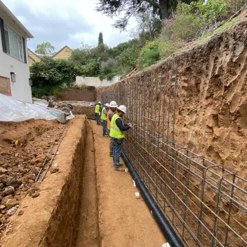 Crew constructing an engineered concrete retaining wall