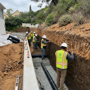 Crew installing reinforced earth retaining wall layers