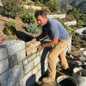 Contractor building a decorative stone garden wall