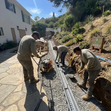 Crew installing drainage beside a hardscape patio