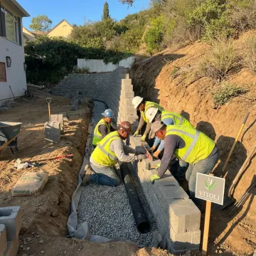 Crew constructing a hillside retaining wall