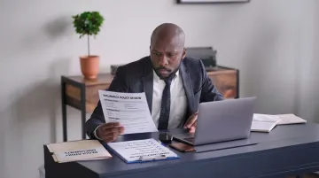 Small business owner reviewing workers compensation insurance documents