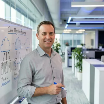 IT consultant presenting a phased infrastructure migration roadmap on a whiteboard