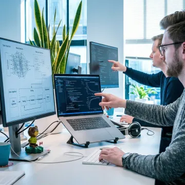 AI consultants collaborating on a machine learning deployment pipeline in a tech office