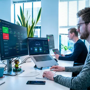 Enterprise DevOps consulting team reviewing CI/CD pipeline dashboards in a modern office
