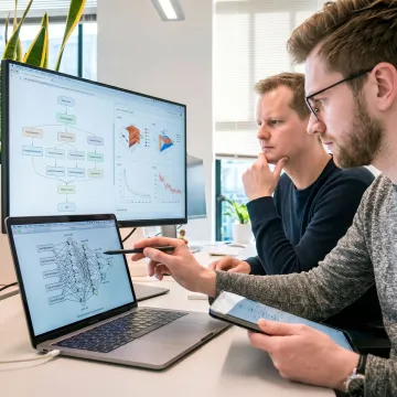 Custom AI development team reviewing machine learning dashboards