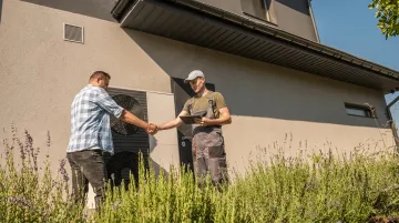 Satisfied homeowner shaking hands with contractor after successful service call completion