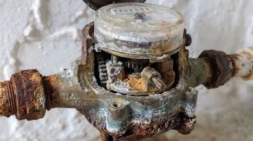 Close-up of mineral scale buildup inside old water meter internal components
