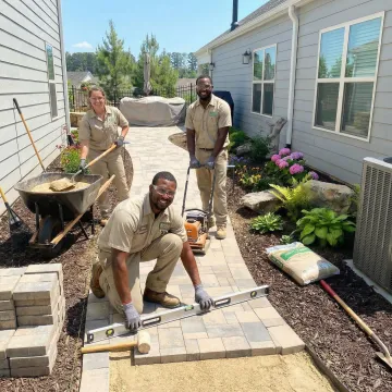 Professional landscaping construction crew installing custom hardscape features in a Marietta, GA backyard