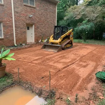Professional yard grading equipment leveling residential property