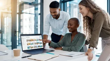 Hospitality marketing team reviewing hotel social media strategy on laptop screens