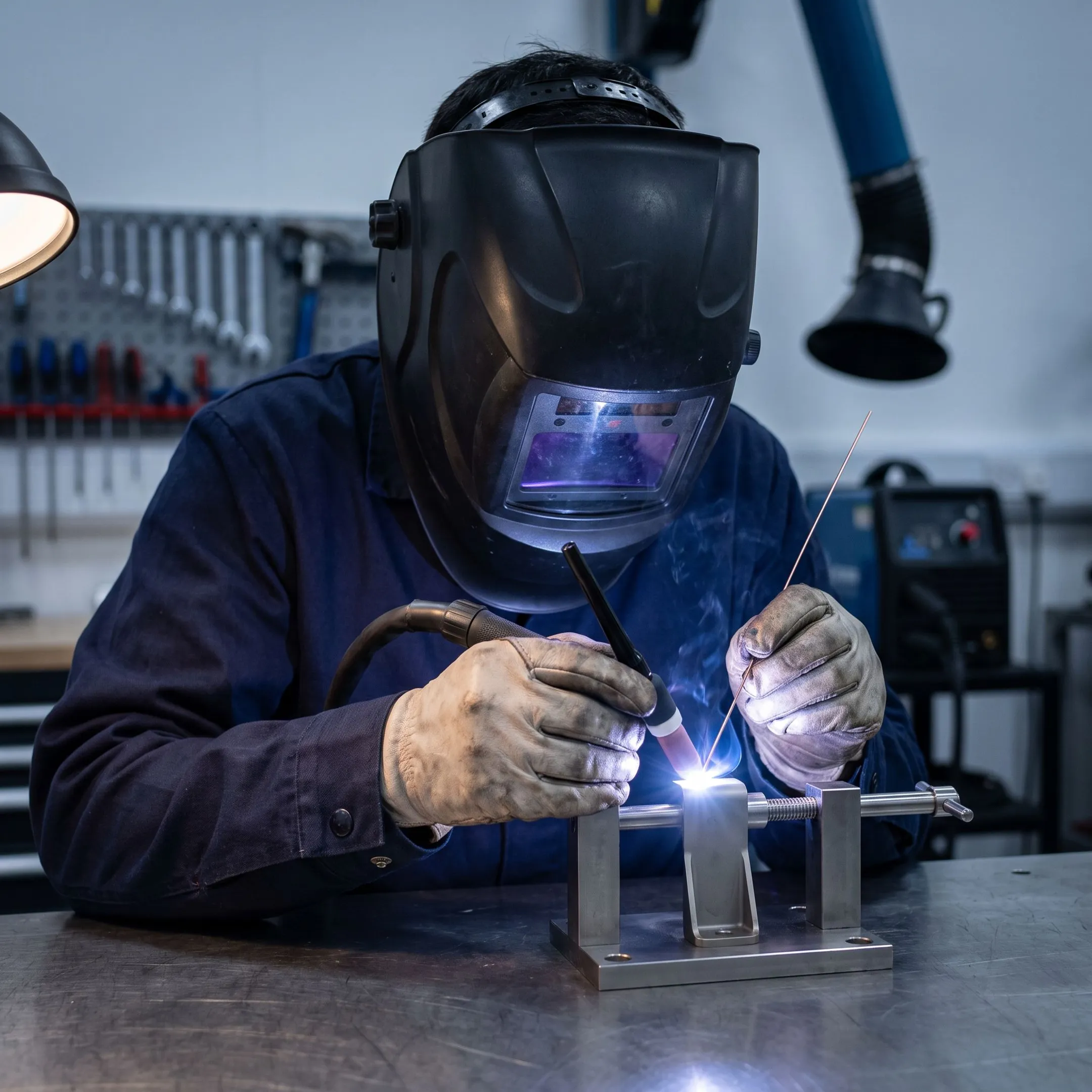 Technician precision welding an aerospace metal component