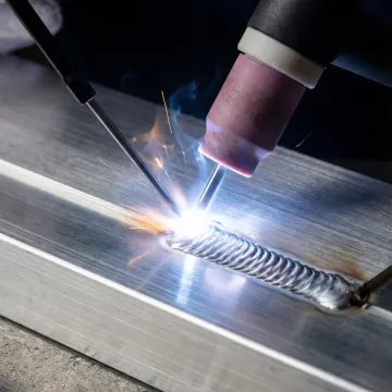 Close-up view of professional aluminium welding with sparks and precision equipment