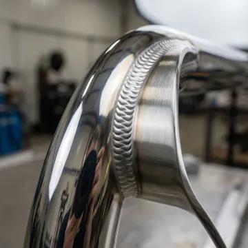Close-up of pristine TIG weld on stainless steel railing showing precision craftsmanship