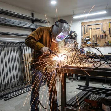 Skilled craftsman working on custom ironwork and patio cover installation