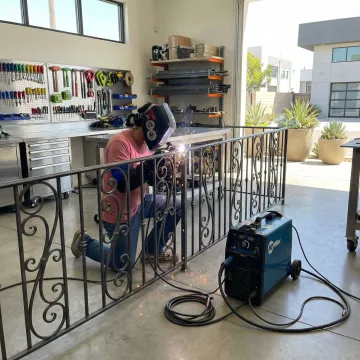 Custom wrought iron railing installation process showing welding work